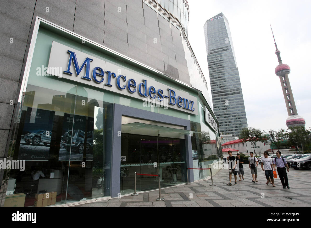 --FILE--Pedestrians walk past a branch of Mercedes-Benz dealership store in Shanghai, China, 5 July 2013.   Daimler AGs Mercedes-Benz expects to see g Stock Photo