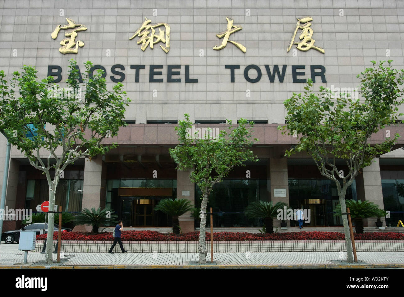 FILEA pedestrian walks past the Baosteel Tower in Shanghai, China