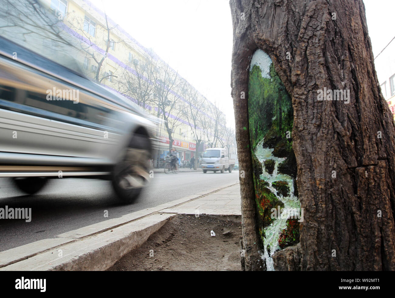 --FILE--A taxi drives past a tree hole painted by Chinese college student Wang Yue on a street in Shijiazhuang city, north Chinas Hebei province, 22 F Stock Photo