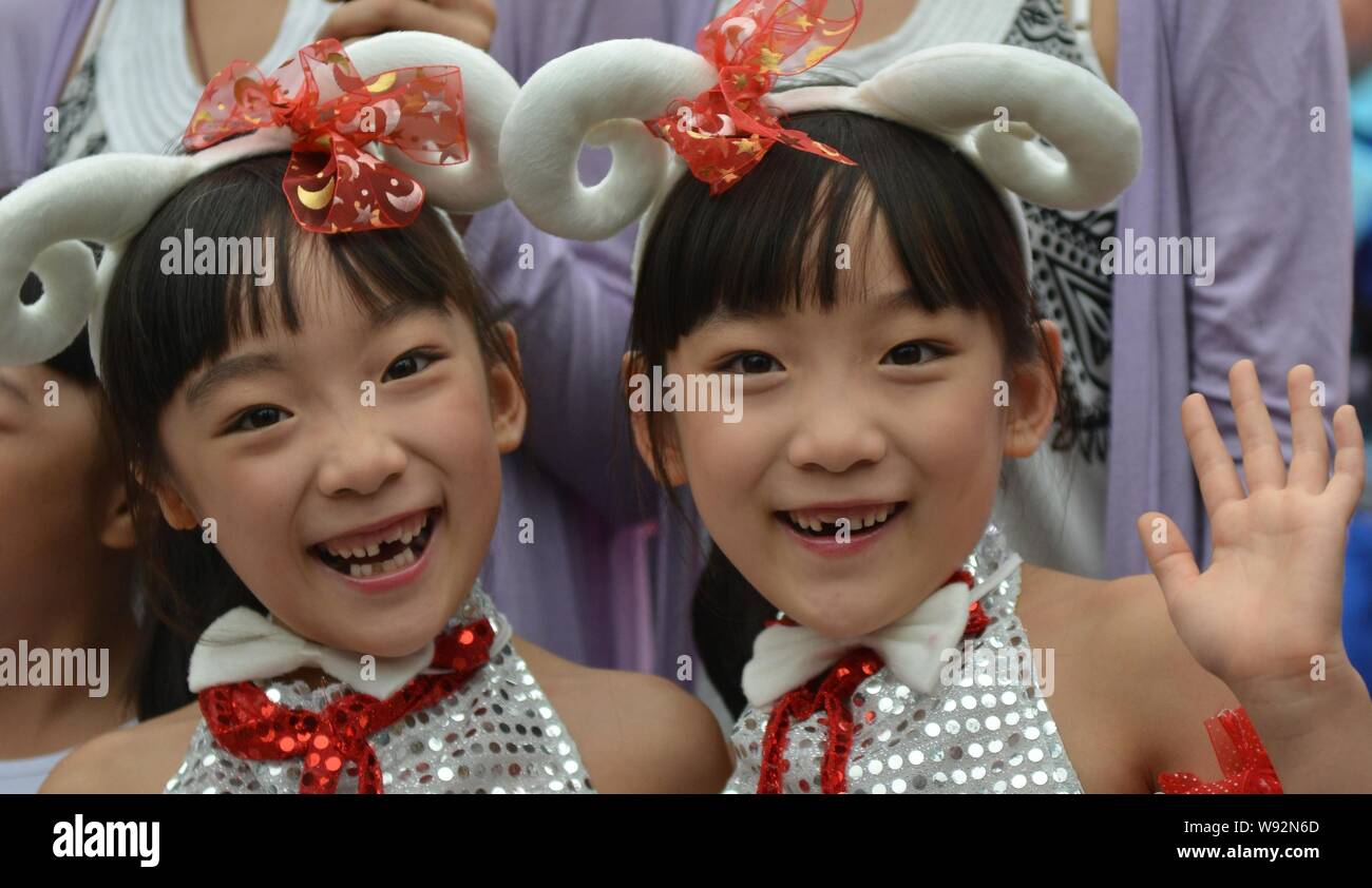 A pair of young Chinese twin sisters attends the launch ceremony of the