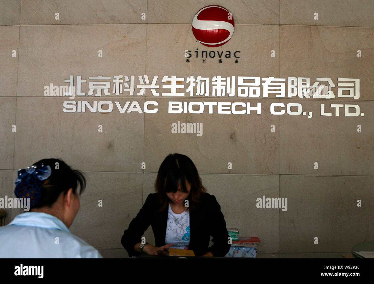 --FILE--Chinese employees work at the front desk of Sinovac Biotech Co., Ltd. in Beijing, China, 15 September 2009.   China-based Sinovac Biotech Ltd. Stock Photo