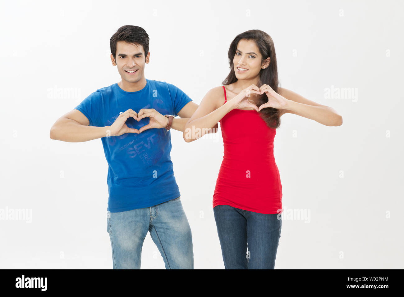 Young couple making heart shape with hands and smiling Stock Photo - Alamy