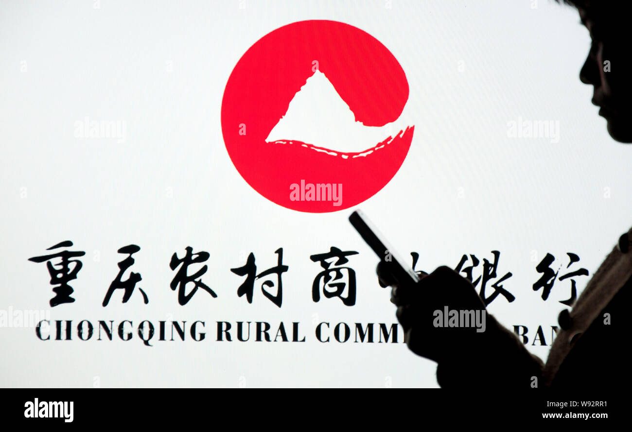 --FILE--A man uses his mobel phone in front of an advertisement of Chongqing Rural Commercial Bank in Shaoyang city, central Chinas Hunan province, 30 Stock Photo