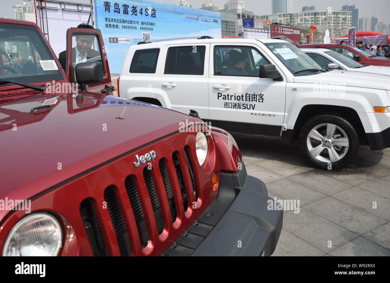 FILE--Jeep Wrangler and Patriot SUVs of Chrysler are displayed during an  auto show in Qingdao city, east Chinas Shandong province, 14 April 2013  Stock Photo - Alamy