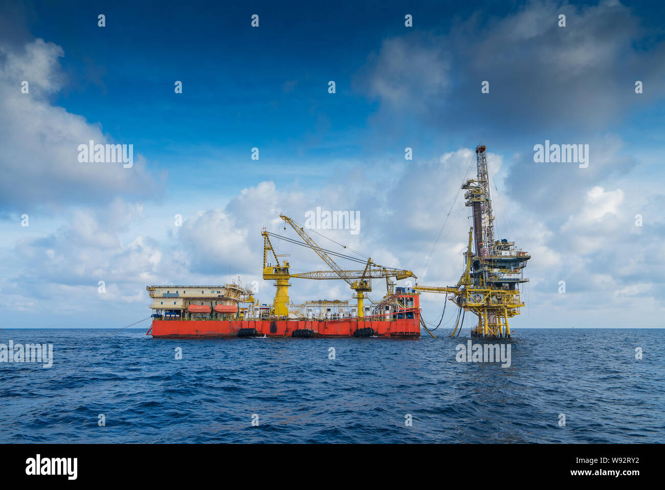Offshore oil and gas production and exploration, tender rig work over remote platform to completion gases and crude oil wells, Drilling service barge. Stock Photo