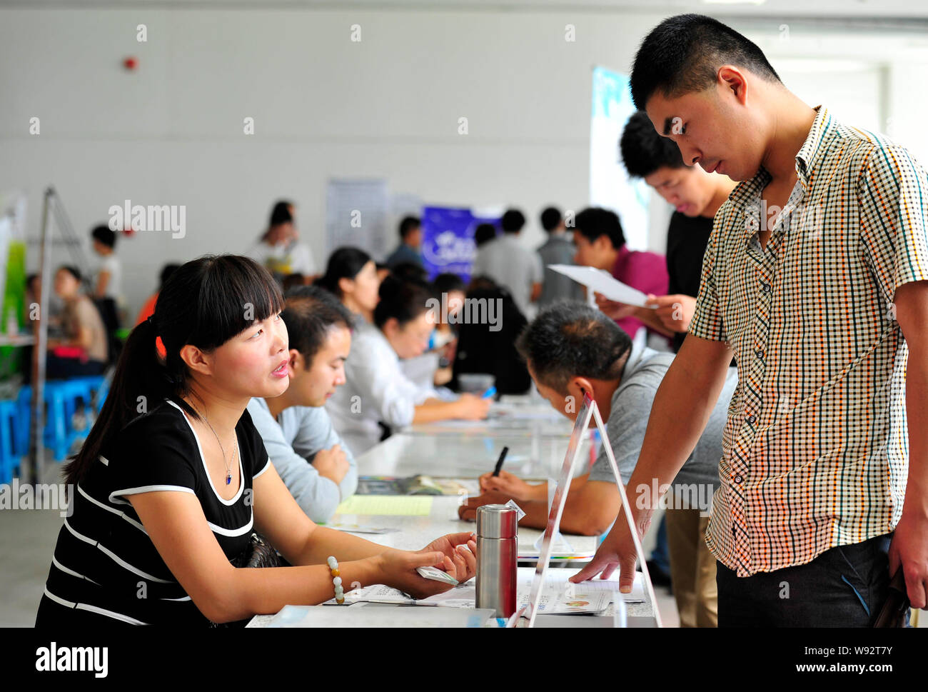 --FILE--A Chinese graduate job searcher talks with an interviewer during a job fair in Huaian, east Chinas Jiangsu province, 14 September 2013.   Acad Stock Photo