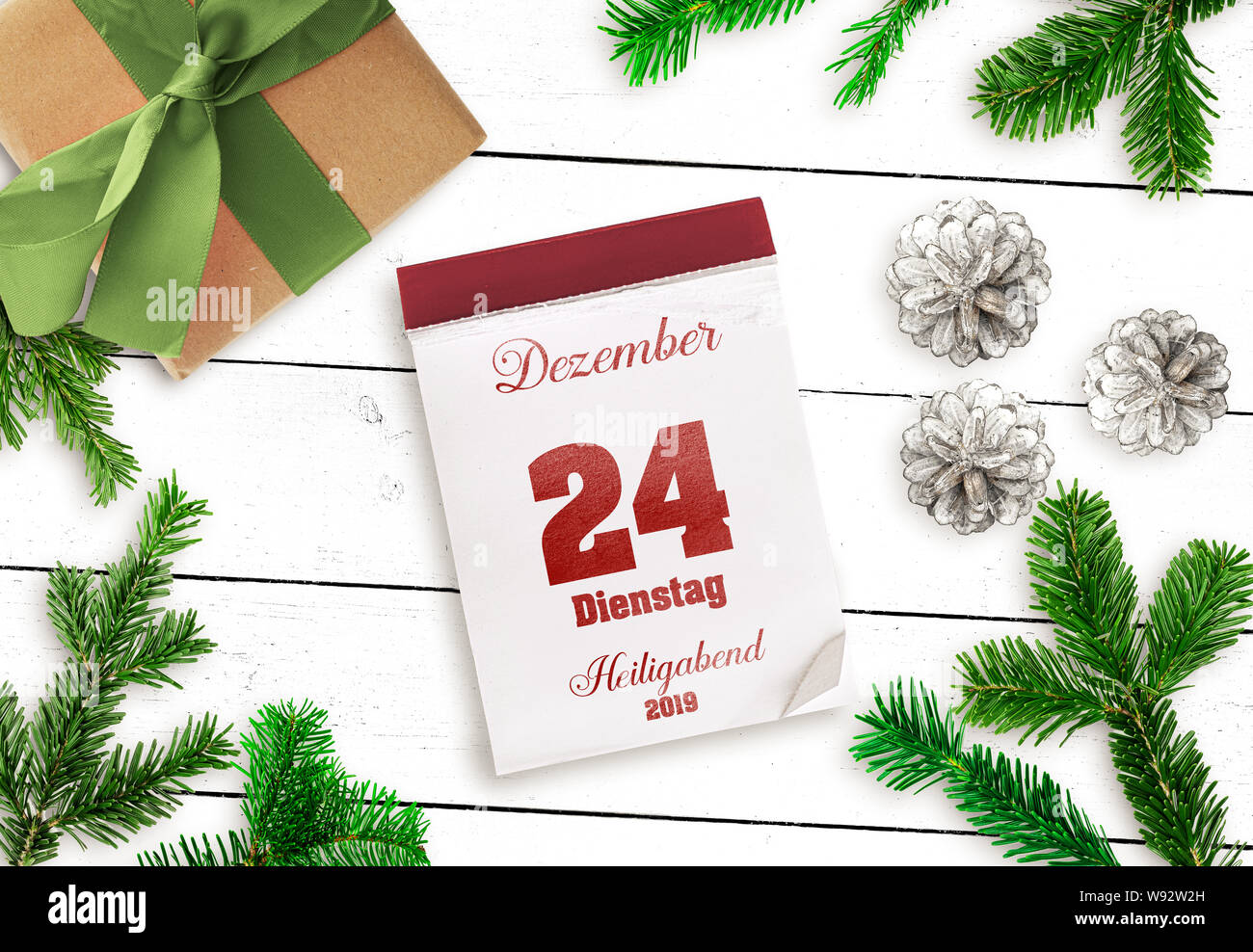top view of tear-off calendar on December 24 Christmas Eve 2019, in German language, on white wooden table Stock Photo