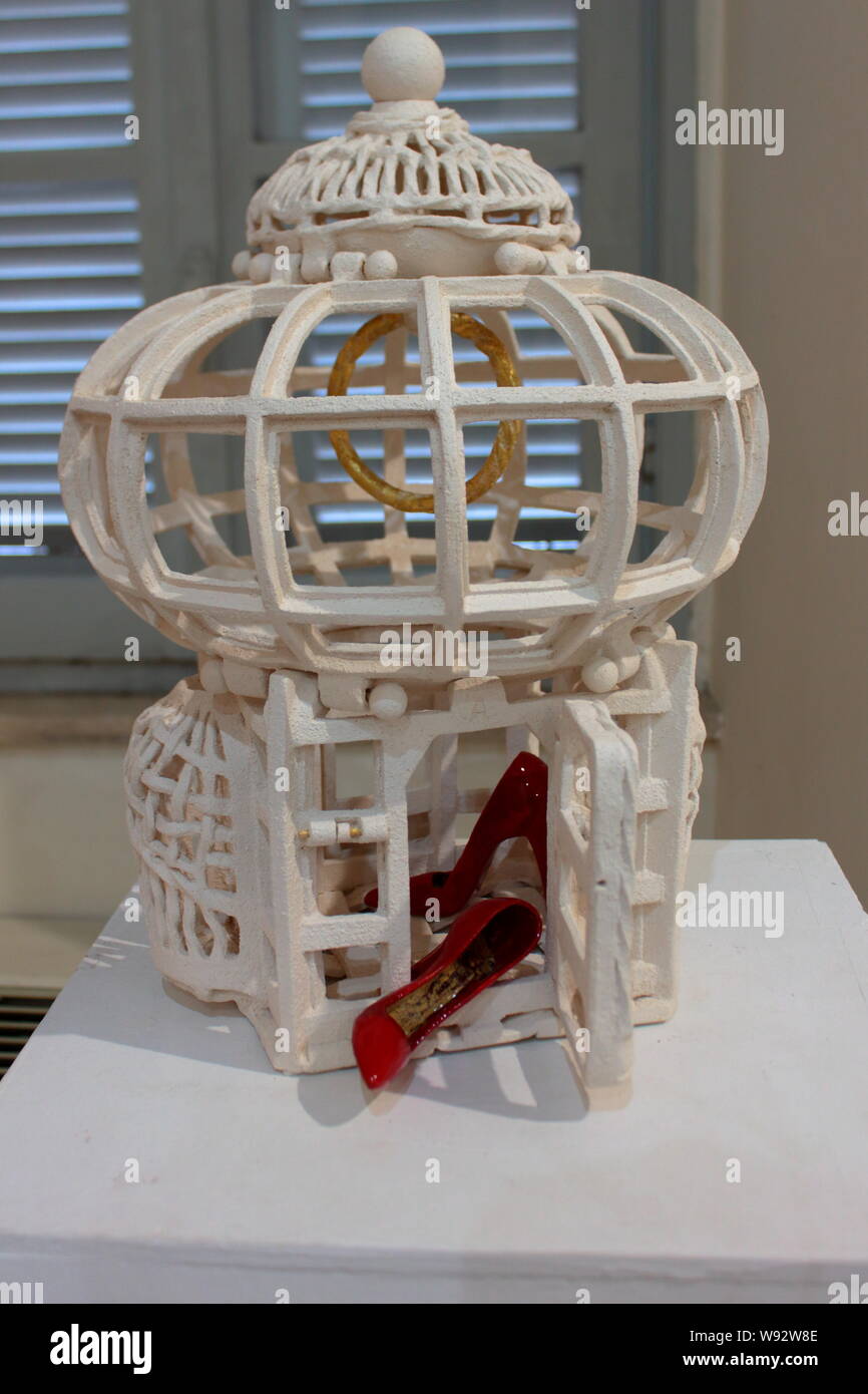the false love, represented by the cage, which traps an abused woman, represented by the red shoes Stock Photo