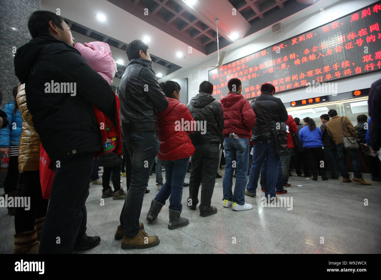 --FILE--Migrant workers queue up to buy train tickets in group at the Shanghai Railway Station in Shanghai, China, 7 January 2013.   Transport authori Stock Photo