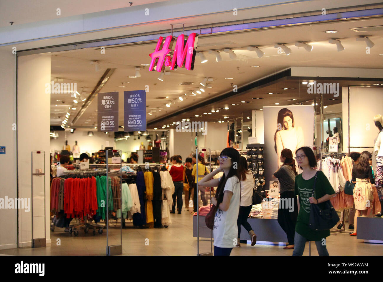 FILE--Consumers walk past a store of high street fashion brand H&M in  Shanghai, China, 28 September 2012. In cases involving poor product quality  Stock Photo - Alamy