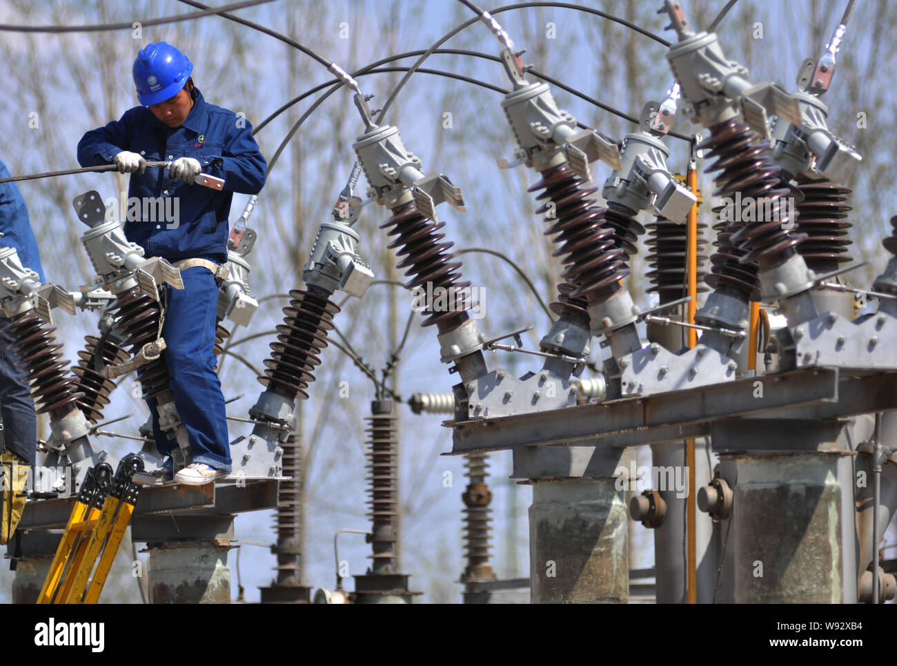 FILEA Chinese electrician installs power lines at a transformer
