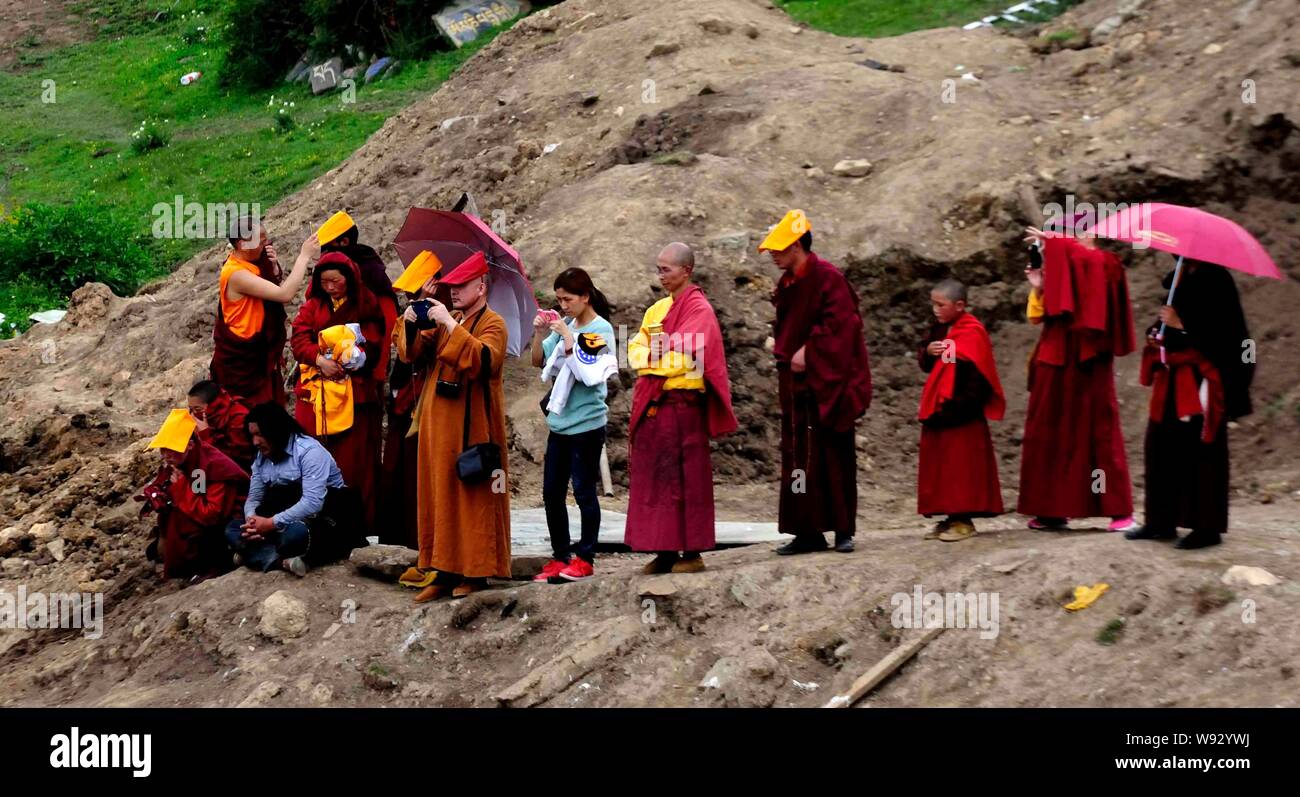 Local lamas and tourists look at a flock of vultures after a sky burial in Sertar county, Ganzi Tibetan Autonomous Prefecture, southwest Chinas Sichua Stock Photo