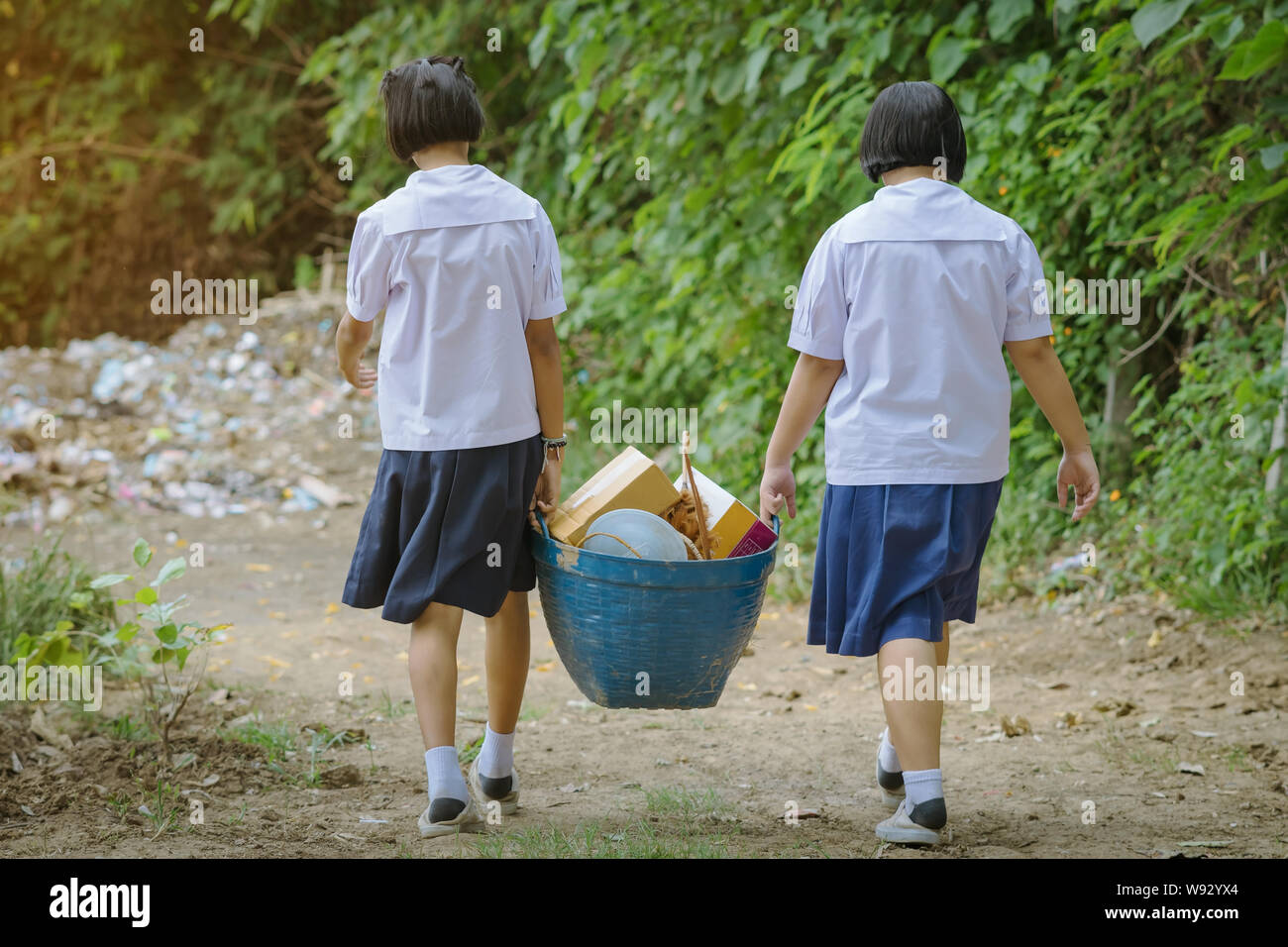 Female Students help to remove rubbish from the classroom to pile waste