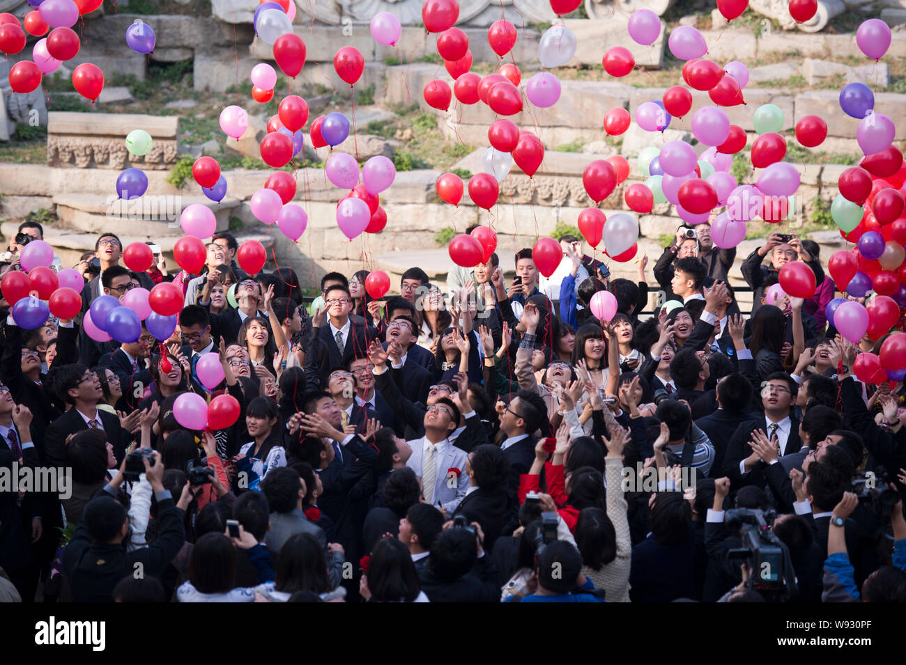 Young Chinese students from Beijing 101 Middle School release balloons at a coming-of-age ceremony at Yuanmingyuan, also known as the Old Summer Palac Stock Photo