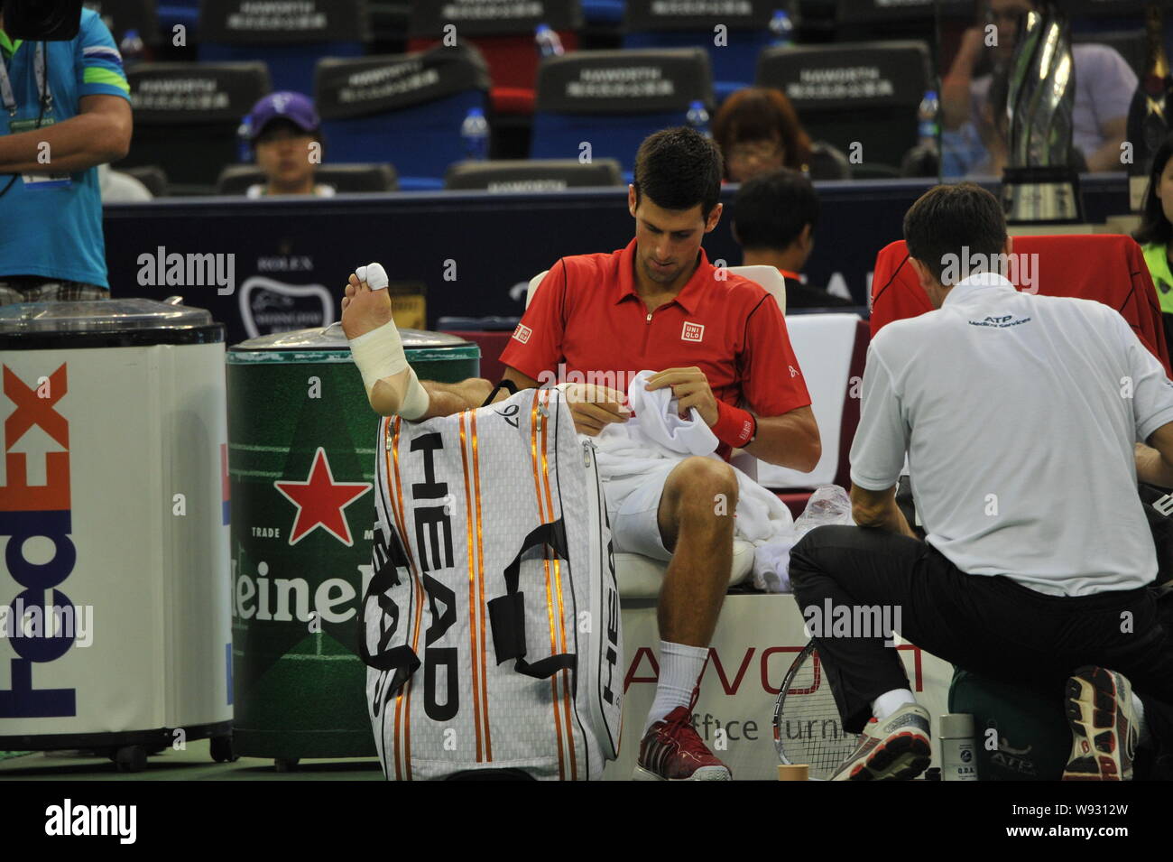 Serbias Novak Djokovic receives medical attention on his foot during a match against Spains Marcel Granollers for the Shanghai Masters tennis tourname Stock Photo