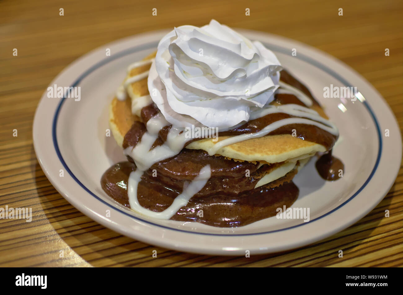 Stack of pancakes from International House of Pancakes (IHOP). Layered with a luscious cinnamon roll filling, drizzled with rich cream cheese icing. Stock Photo