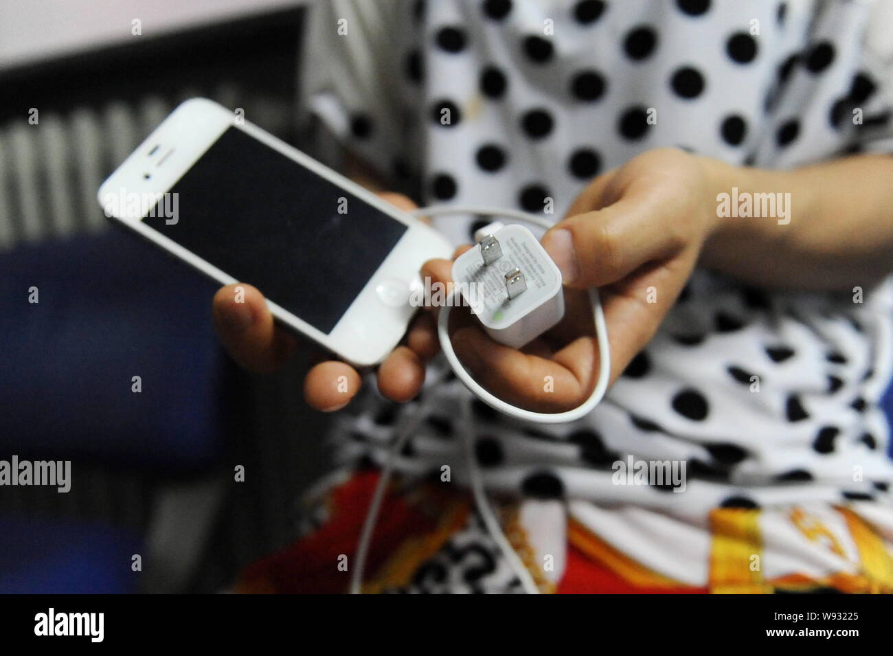 Apple iPhone 4s and charger In the UK there have been a spate of accidents  involving fake chargers being used with mobile phones Stock Photo - Alamy