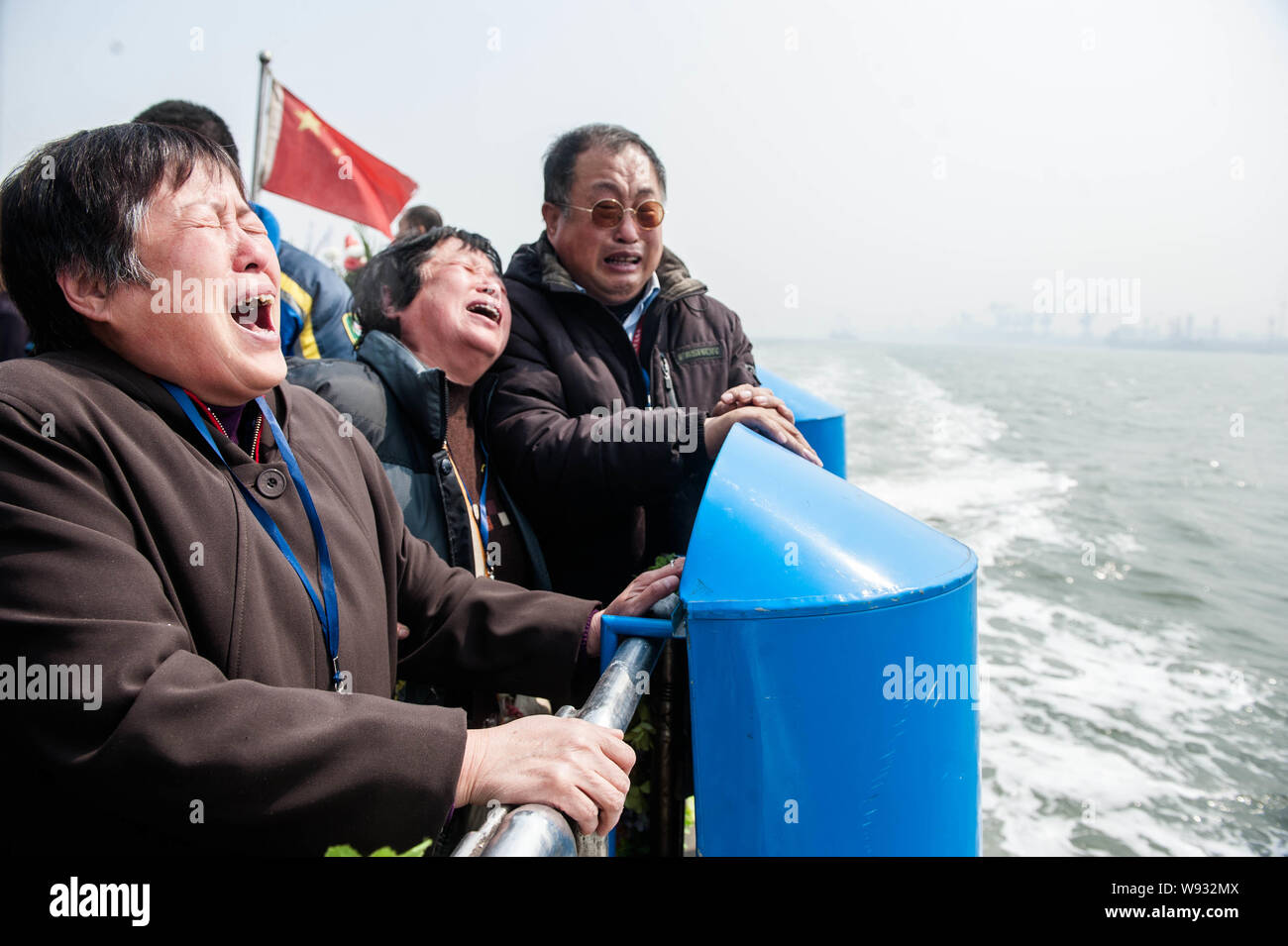 Members of a Chinese family weep during a sea burial ceremony on ship in Tianjin, China, 3 April 2013. Stock Photo