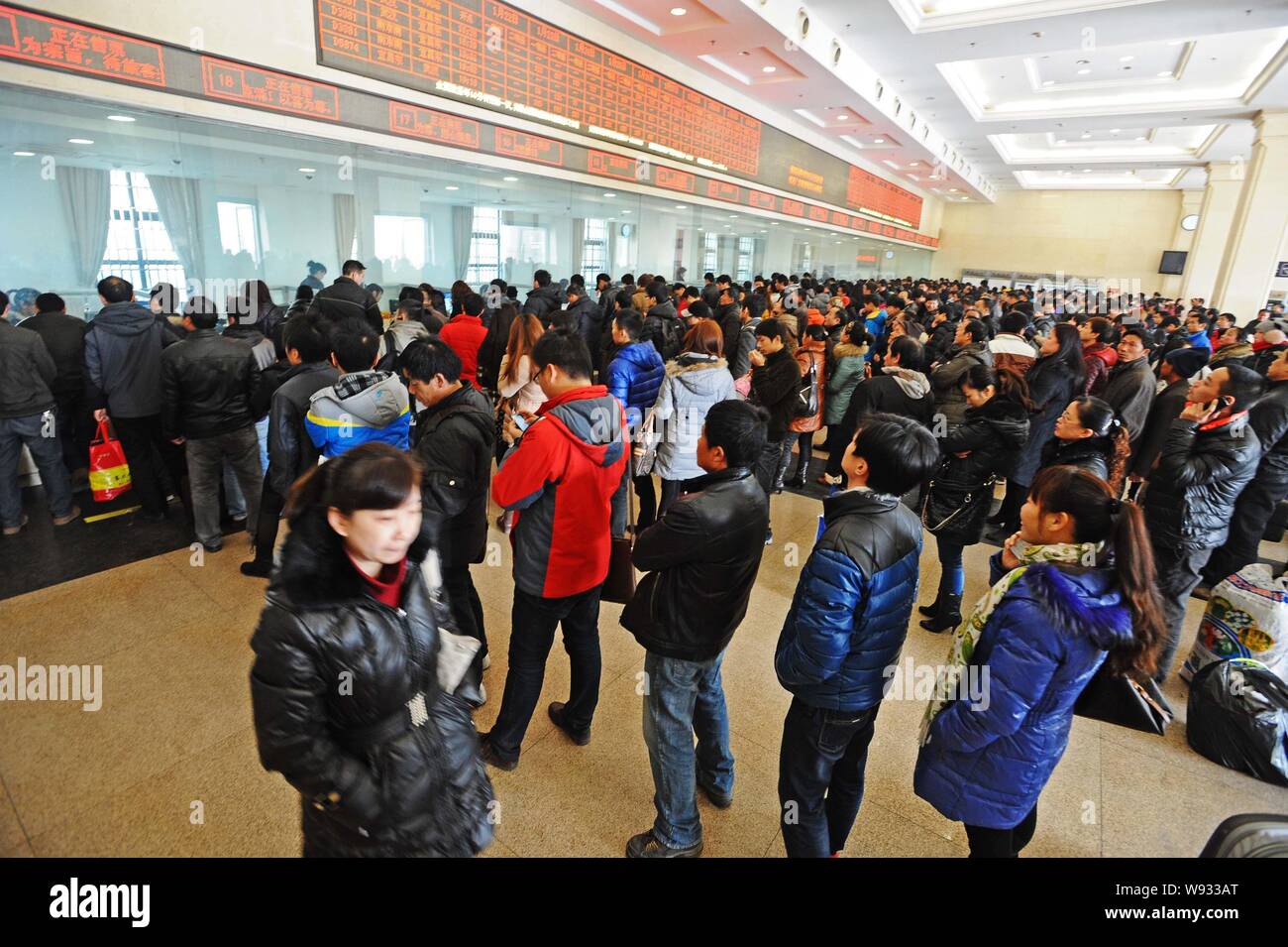 --FILE--Chinese passengers queue up to buy train tickets at the Wuhan Railway Station in Wuhan city, central Chinas Hubei province, 24 January 2013. Stock Photo