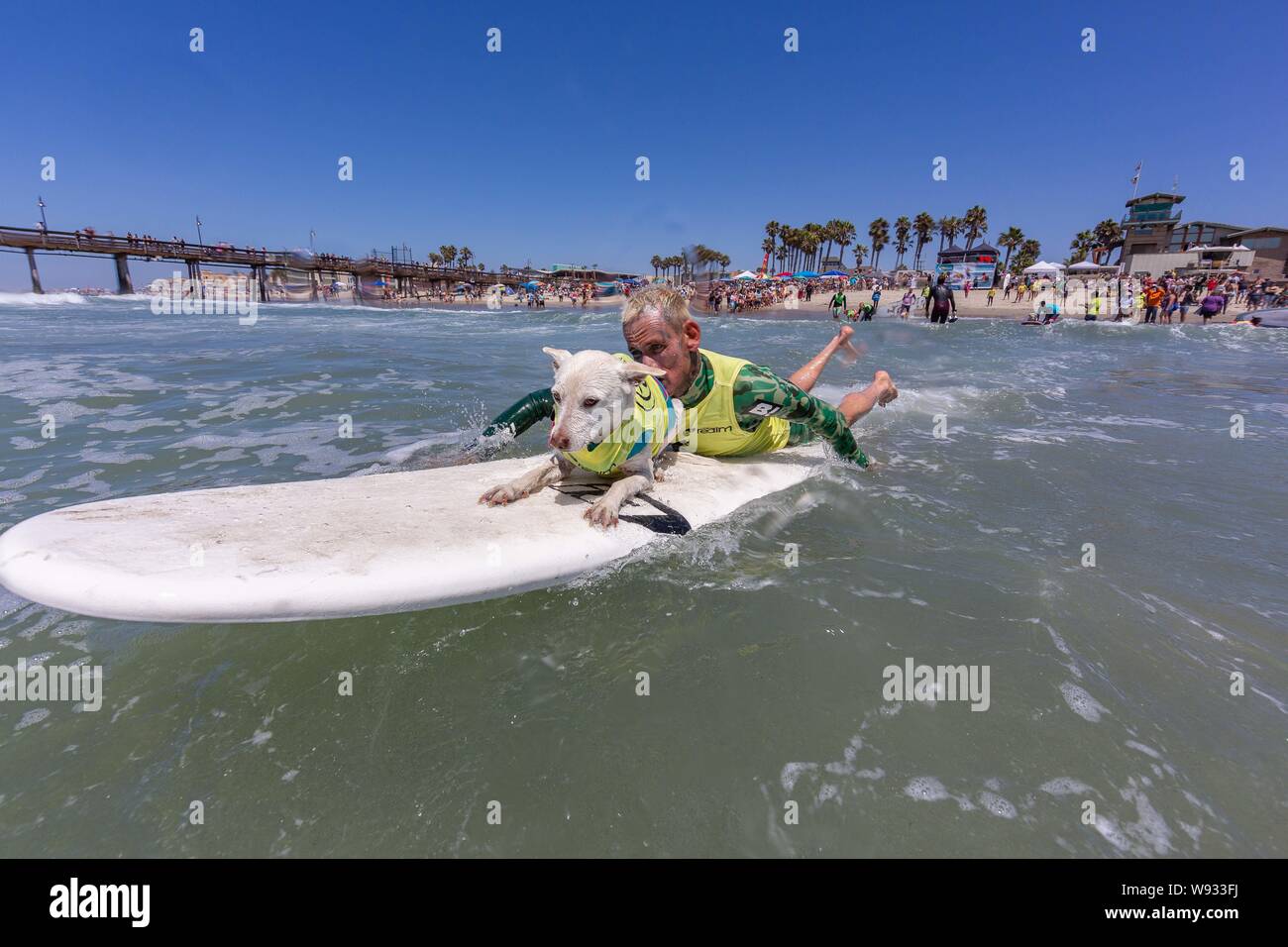 Imperial Beach, CA, USA. 10th Aug, 2019. Owners and their dogs turned out once again to hit the surf at the 14th annual Imperial Beach Surf Dog Competition.Where fearless surFURs jump on their boards and hang 20 right next to the IB Pier!. Seen here Ryan and Sugar Credit: Daren Fentiman/ZUMA Wire/Alamy Live News Stock Photo