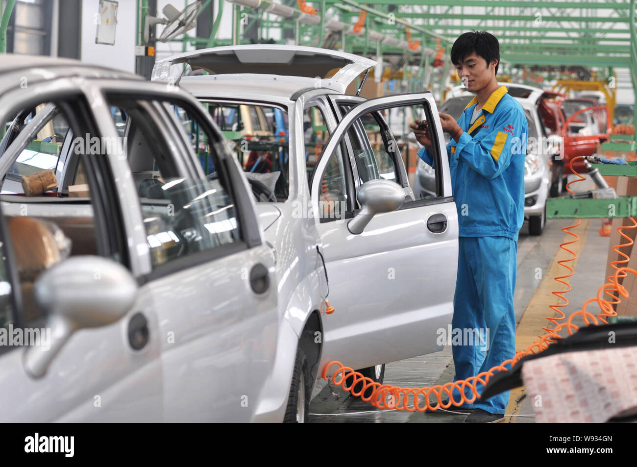 --FILE--A Chinese worker assembles electric cars on an assembly line at ...