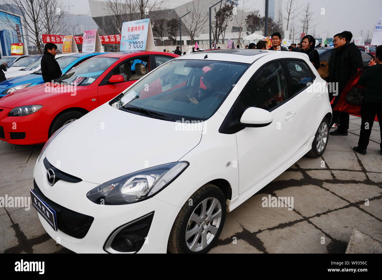 --FILE--Visitors look at cars during an auto show in Liaocheng city, east Chinas Shandong province, 23 February 2013.   Chinas auto sales accelerated Stock Photo