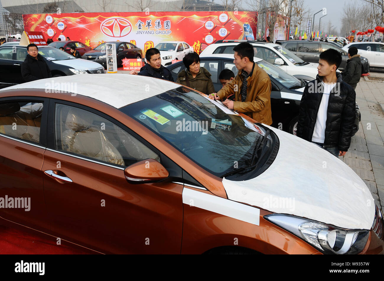 --FILE--Visitors look at cars during an auto show in Liaocheng city, east Chinas Shandong province, 23 February 2013.   Chinas auto sales accelerated Stock Photo