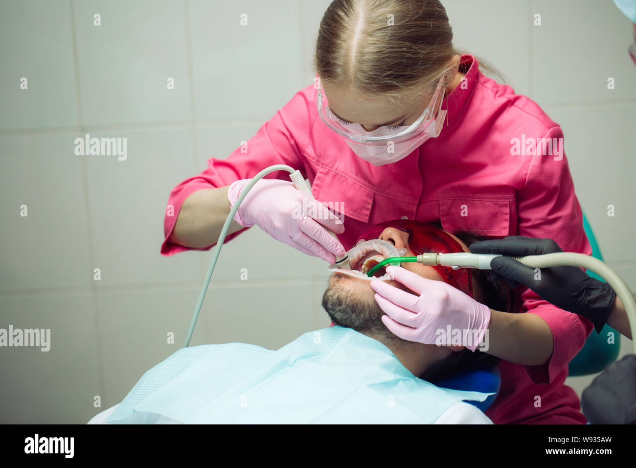 Professional teeth cleaning. Dentist cleans the teeth of a male patient