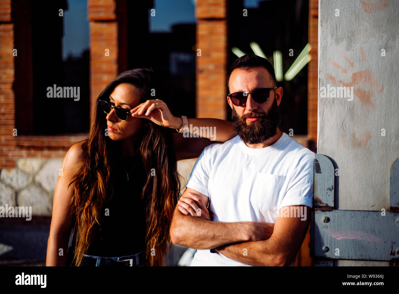 Couple of man and woman posing at sunset with sunglasses Stock Photo ...