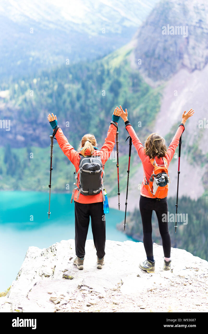 Two strong hikers hands up in the air happy about awesome view Stock Photo