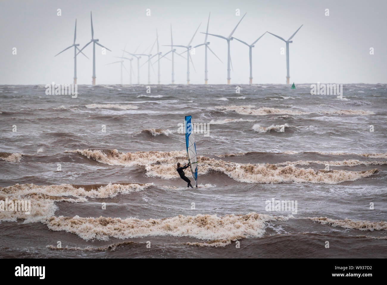 Windsurfer in the river Mersey at Crosby beach on a stormy day. Windpower. Liverpool Bay offshore windfarm. Clean green electricity. Stock Photo