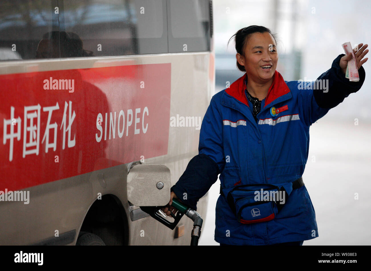 --FILE--A Chinese worker refuels a car at a gas station of Sinopec in Huaibei, east Chinas Anhui province, 15 November 2013.    Chinas largest refiner Stock Photo