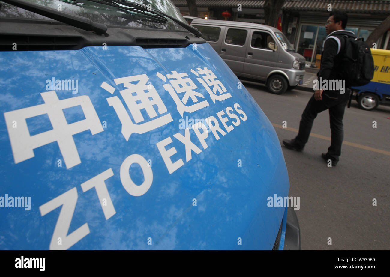 FILE--A pedestrian walks past a parcel delivery vehicle of ZTO Express in  Beijing, China, 1 May 2013. Chinas major express delivery firms mostly o  Stock Photo - Alamy