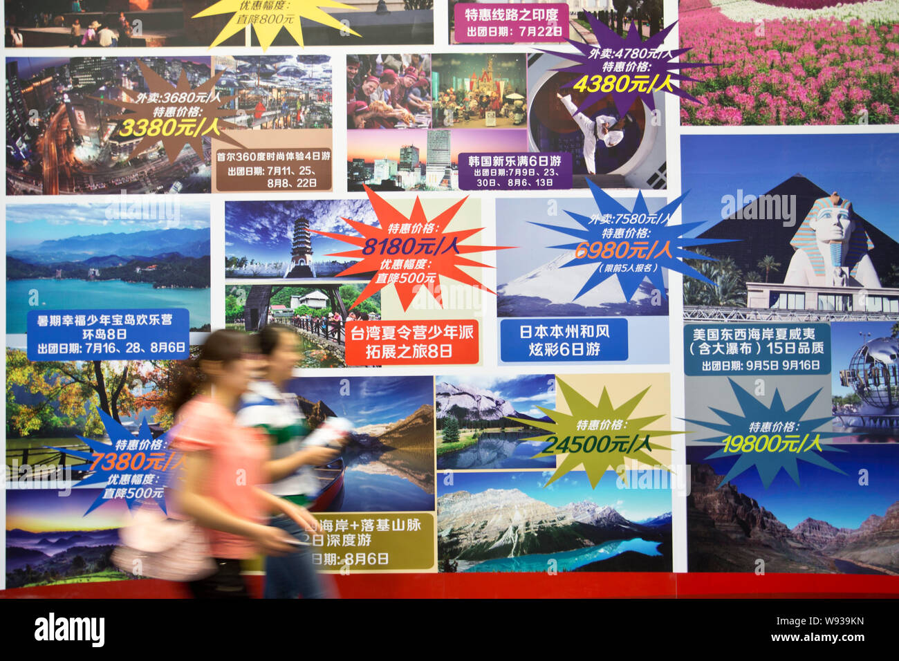 --FILE--Visitors walk past advertisements for travelling abroad during the Beijing International Tourism Expo (BITE) 2013 in Beijing, China, 21 June 2 Stock Photo