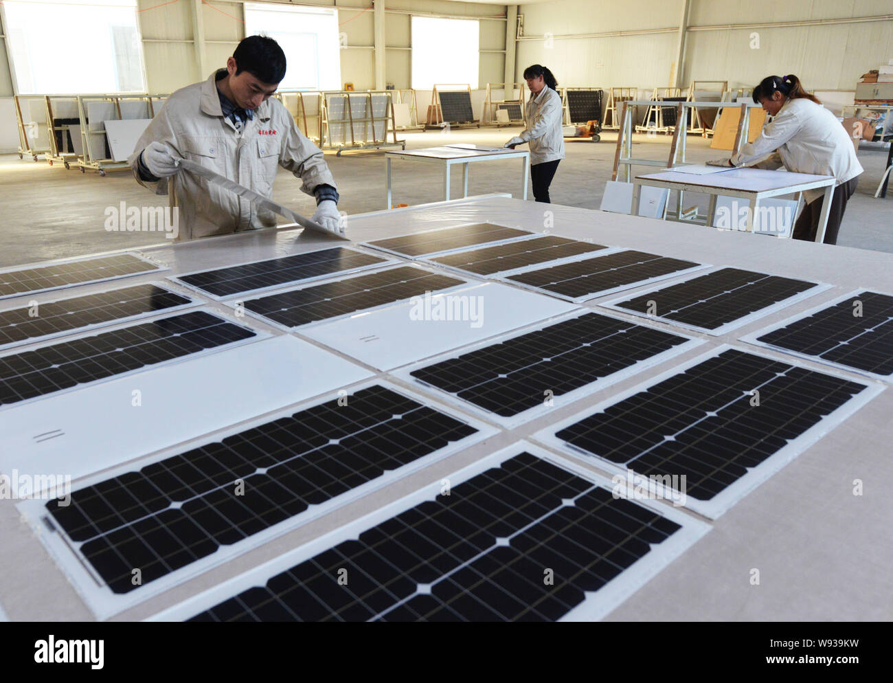 --FILE--Chinese workers examine solar panels at the factory of Shandong Hilight Solar Co., Ltd. in Zouping county, Binzhou city, east Chinas Shandong Stock Photo