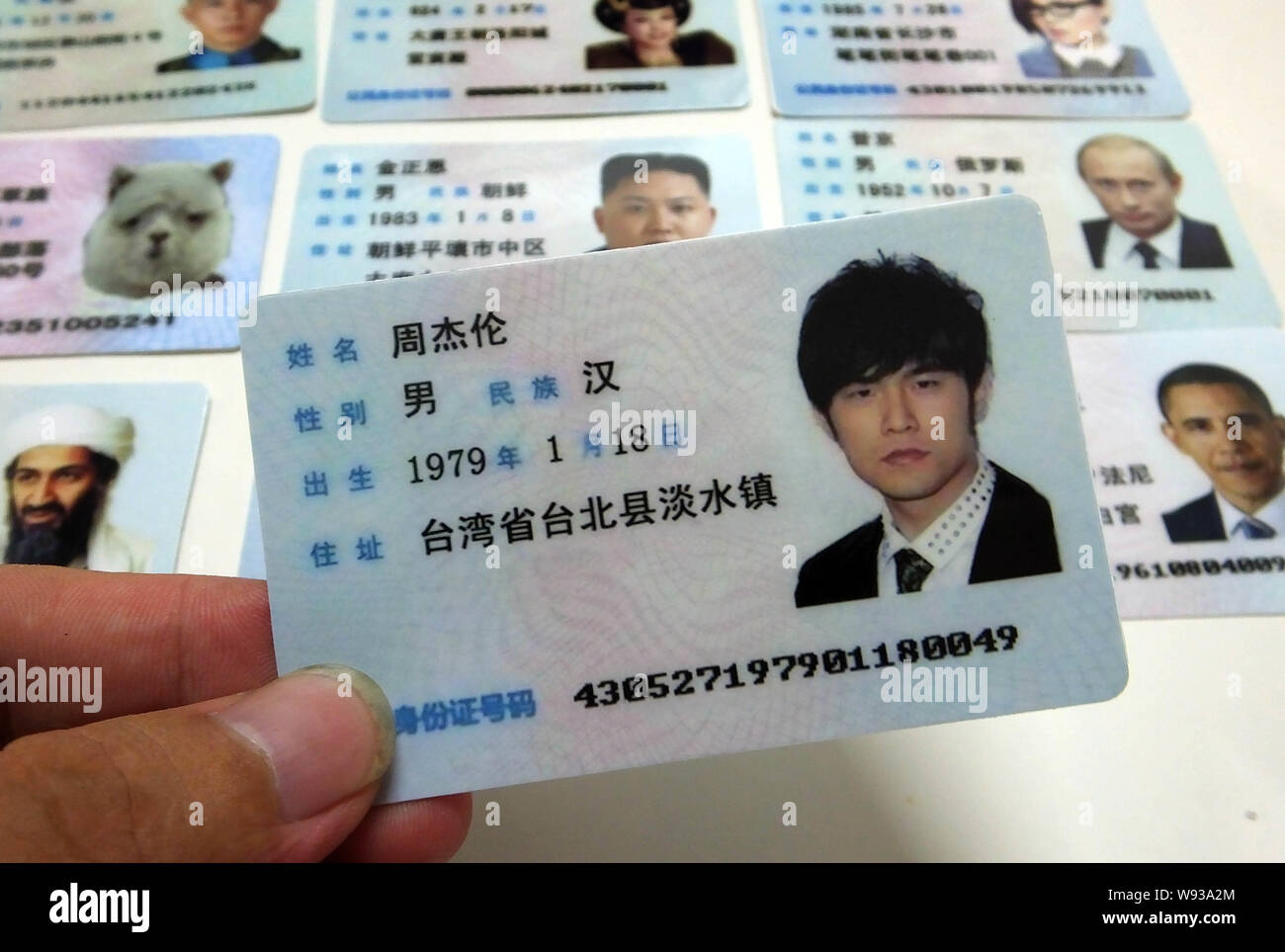 A man shows a fake Chinese ID card of Taiwanese singer and actor Jay Chou  for sale at a stall on a street in Guangzhou city, south Chinas Guangdong  pr Stock Photo -