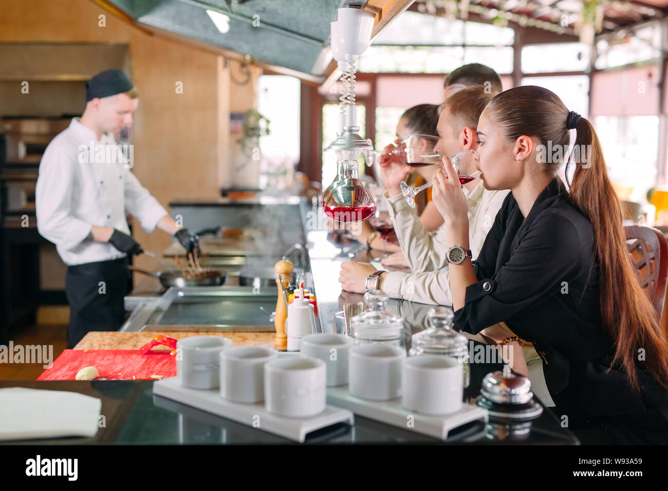 The chef prepares food in front of the visitors in the restaurant Stock Photo