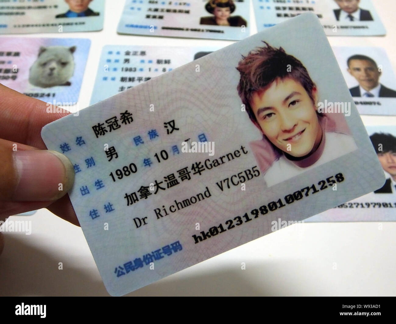 A man shows a fake Chinese ID card of Hong Kong singer and actor Edison Chen