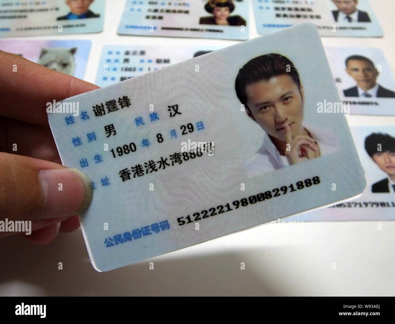 A man shows a fake Chinese ID card of Hong Kong singer and actor Nicholas  Tse