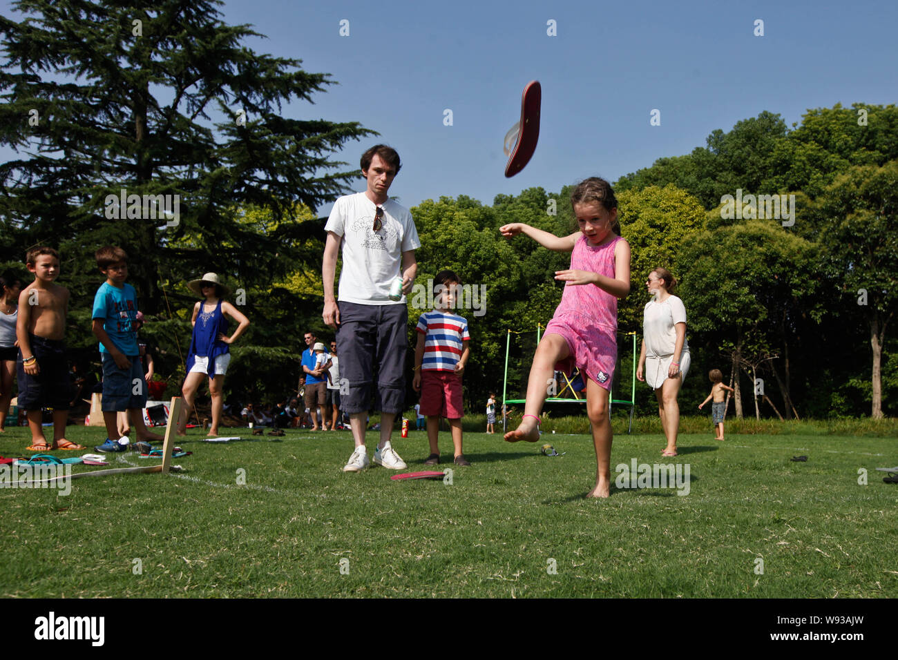 A foreign child entrant, front, kicks a flip-flop during the 4th Throw ...