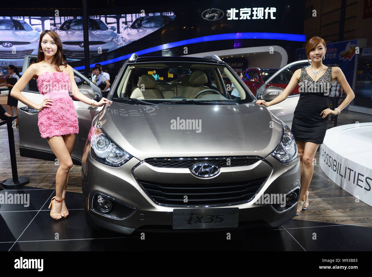 --FILE--Models pose with a Hyundai ix35 SUV during the 15th Chengdu Motor Show 2012 in Chengdu city, southwest Chinas Sichuan province, 31 August 2012 Stock Photo