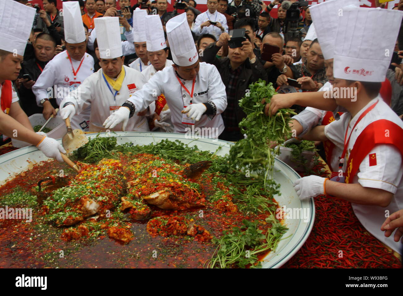 Chinese chefs cook a giant dish of steamed fish head with diced hot peppers during the 23rd Chinese Chef Festival in Changsha, central Chinas Hunan pr Stock Photo