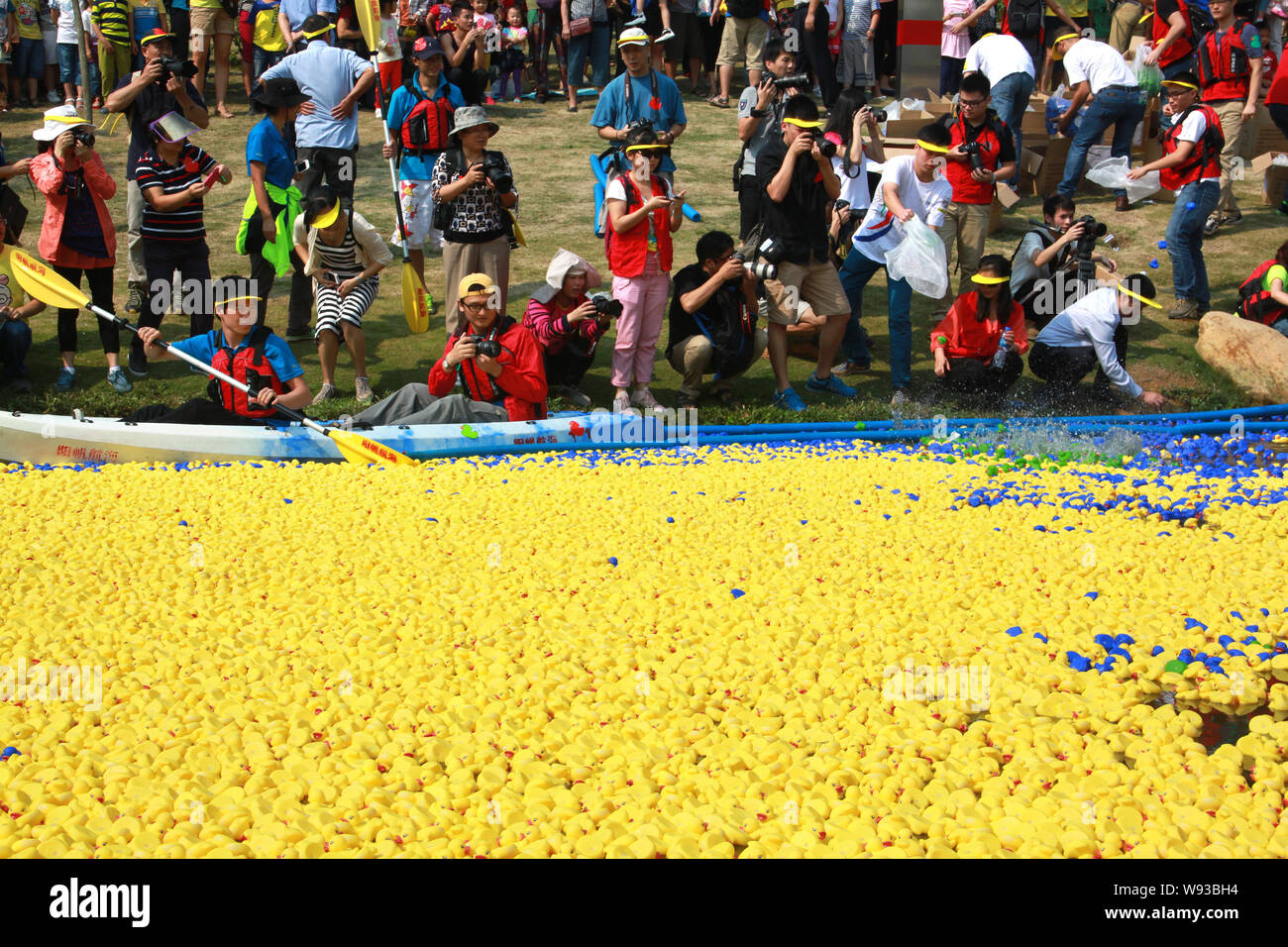 A staff member is fishing the rubber ducks floating in Futian River out of  the water after they reached the end point during a charity event at Shenzh  Stock Photo - Alamy