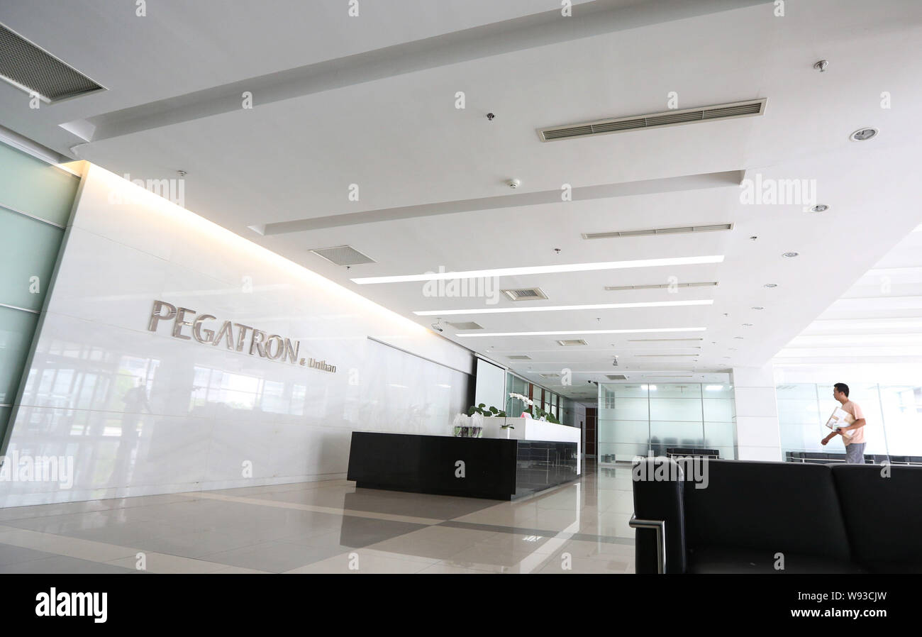 A deliveryman walks to the front desk in a building at the plant of Pegatron-Unihan in Pudong, Shanghai, China, 25 July 2013.   A new report from a Ch Stock Photo