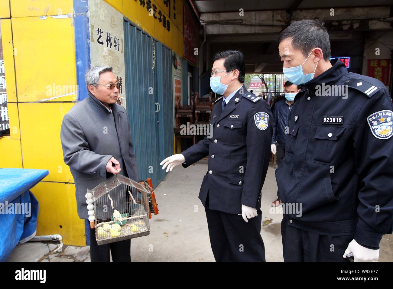 --FILE--Local policemen alert a citizen to protect himself against bird flu at flower market in Huaibei, east Chinas Anhui province, 20 April 2013. Stock Photo