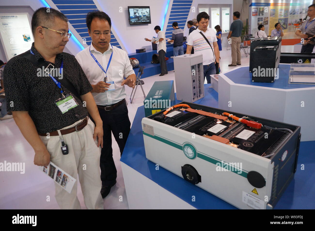 --FILE--An employee of Wanxiang introduces a new car battery to a visitor during an auto-parts exhibition in Hangzhou, southeast Chinas Zhejiang provi Stock Photo