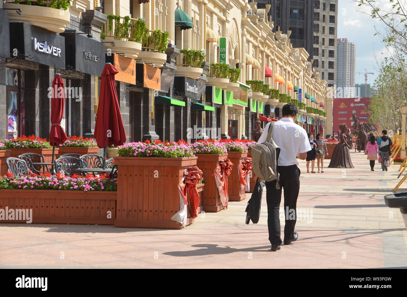 Pedestrians walk on a fake luxury shopping strip in Shenyang, northeast Chinas Liaoning province, 1 September 2013.   China is known to the world for Stock Photo