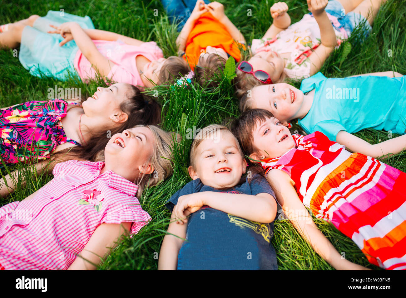 Smiling children lying on grass circle hi-res stock photography and ...