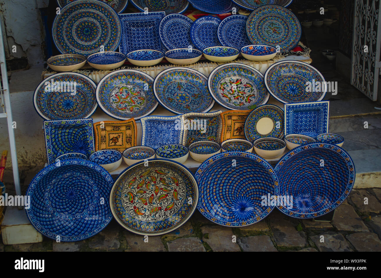 Typical colorful arabic Tunisian handicraft with ornamental patterns. Plates with ornaments are sold in Medina. Stock Photo
