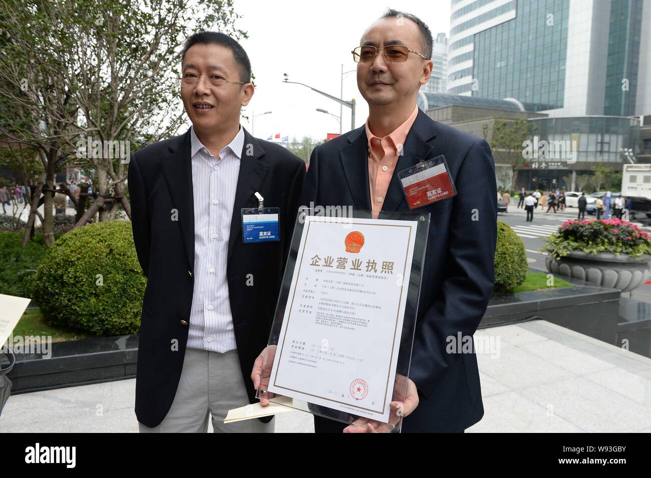 Representatives of Chinese and overseas enterprises pose with a new specialized business license for enterprises in China (Shanghai) Pilot Free Trade Stock Photo